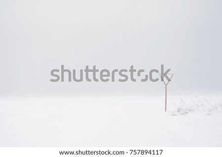 Road sign in the snow in the fog