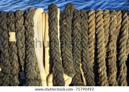 Old sailing ropes on the blue sea background