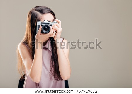 Woman photographer is taking images with dslr camera.
