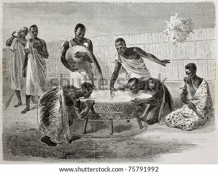 Old illustration of native Ugandan Africans drinking millet beer from a big common recipient. Created by Bayard and Dumont, published on Le Tour du Monde, Paris, 1864