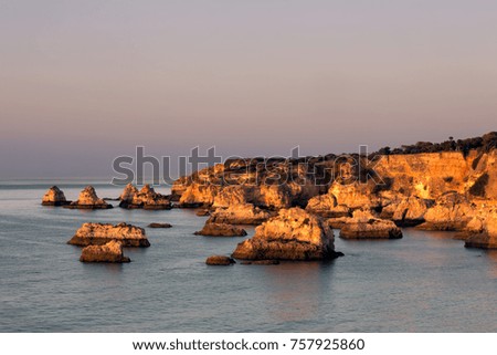 First sunlight warming the eroded cliffs of Algarve region in Portugal