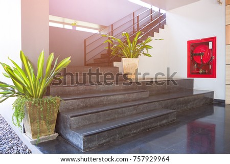 indoor concrete staircase with fire extinguisher and fire hose reel in the modern building