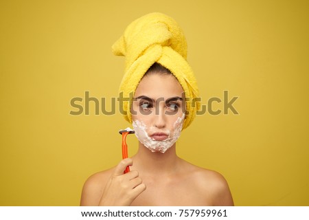   woman with a razor, a towel on her head, facial skin care                             