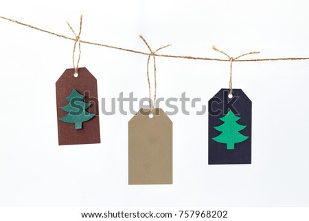 Holiday Christmas tag hanging on a rope isolated on white background