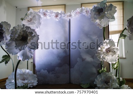 Wall decorated with white paper flowers and large book for a child