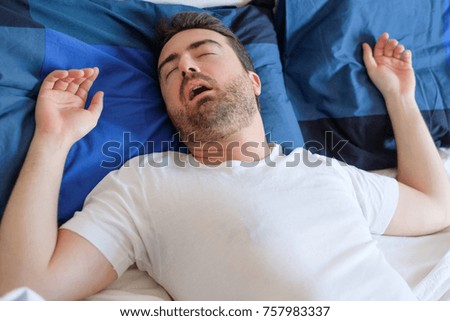  Man in bed suffering for sleep apnea syndrome