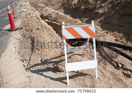 Barricades and open trench on construction job site