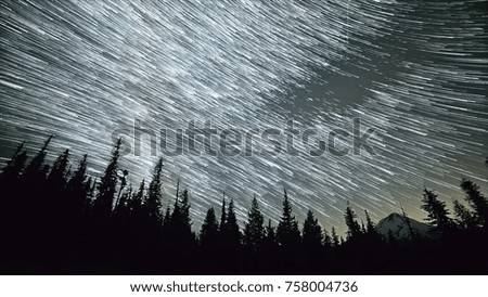 Star trails pass over forest and distant mountain peak - mt. hood oregon