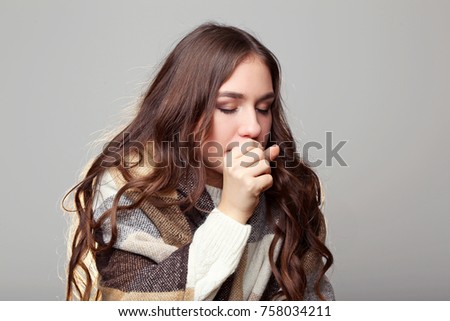 Sick young girl with plaid on grey background