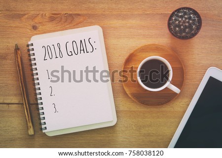 Top view 2018 goals list with notebook, cup of coffee on wooden desk Royalty-Free Stock Photo #758038120