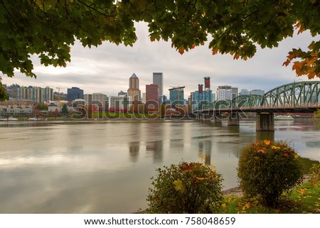 Portland Oregon downtown city skyline framed by fall season foliage along Willamette River
