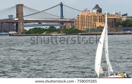 Boat in New York with Brooklyn and Manhattan Bridge in background.