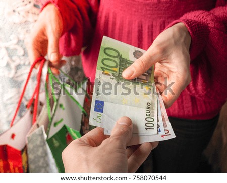 Customer pays euro bills cash while shopping. 