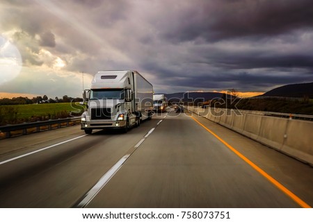 Two white 18 wheelers on highway platooning Royalty-Free Stock Photo #758073751