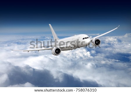 Civil wide-body airliner flying on a high altitude above the clouds. Royalty-Free Stock Photo #758076310