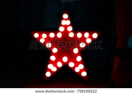 the shape of a red star shining with the help of incandescent lamps on a dark background
bokeh, in the focus, star silhouette               