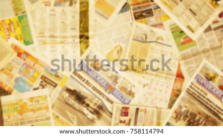 Lots of old newspapers on horizontal surface. Background texture, top view, blurred