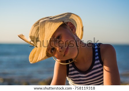 boy in cowboy hat on the seashore