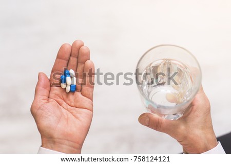 Adult woman holding pills and glass of water. Top view. Health care concept. Royalty-Free Stock Photo #758124121