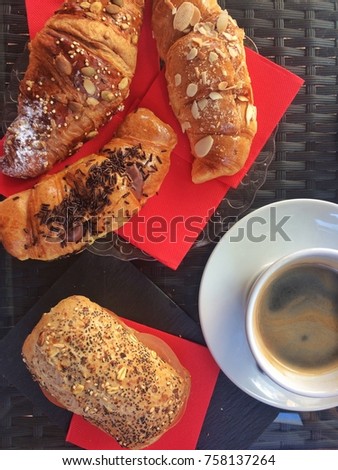 Typical Spanish French breakfast: stock of croissants and cereal sandwich with cup of coffee