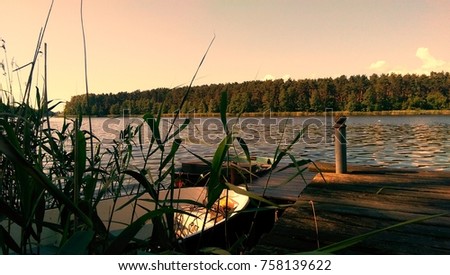 Vintage picture of a lake side with boat, fishing spot
