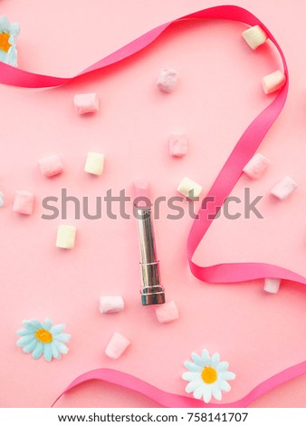 Many cosmetics on pink background, brush, lipstick, ribbon