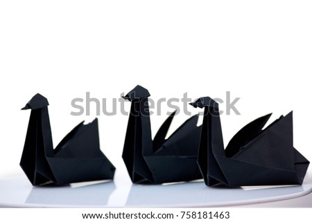 Composition of three black swans on white background. Elegant origami figurines, traditional style.