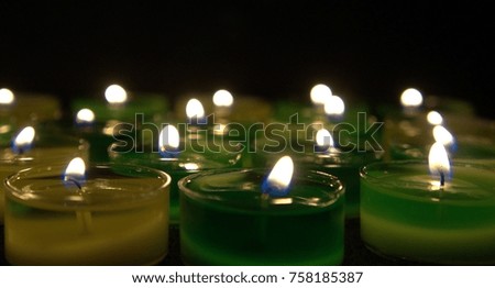 green candles in darkness