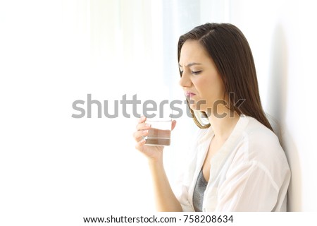 Disgusted woman drinking water with bad taste isolated on white at side Royalty-Free Stock Photo #758208634