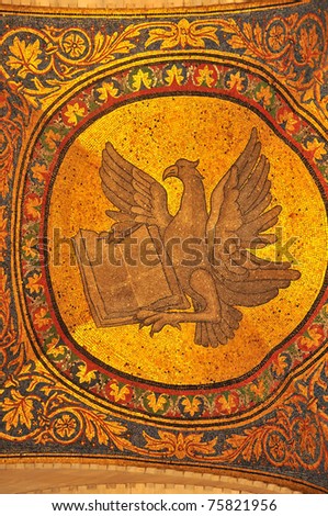 Magnificent golden mosaic of an eagle with bible, symbolising the evangelist John from the basilica of St Mark, Venice, Italy