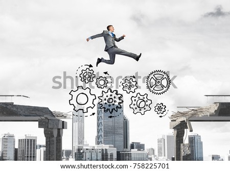Businessman jumping over gap with gear mechanism in concrete bridge as symbol of overcoming challenges. Cityscape on background. 3D rendering.