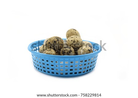 Quail eggs in a blue plastic basket.