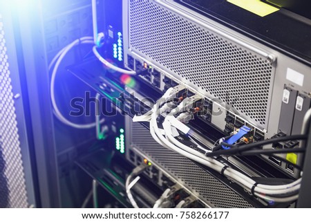 Network panel hardware, switch and cable in data center or server room, database internet communications concept, blue light effect, toned