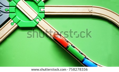 TOP VIEW: Wooden toy train move on curve wooden railways. Green background                        