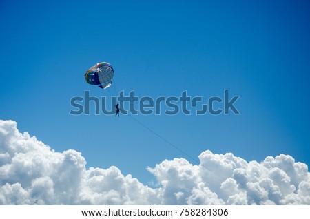 Watersport - tourists parasailing ball on the beach in the sky.