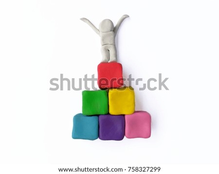 Colorful plasticine clay made are multicolored dice stacked and person stand on top on white background,the most successful,