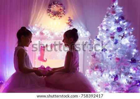 Christmas Girls, Happy Children Giving Present Gift, Lighting Decorated Xmas Tree, Two Kids Celebrating New Year Holiday