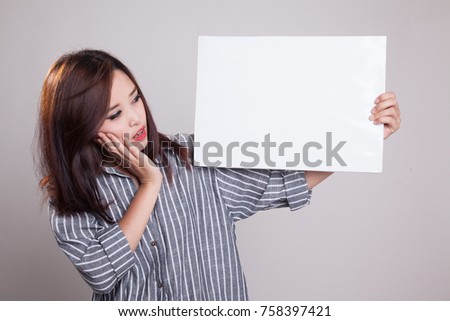 Young Asian woman  surprise with  white blank sign on gray background