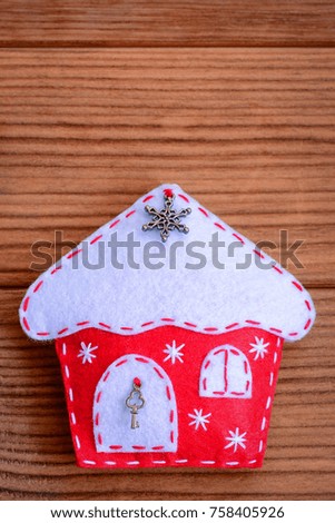 Happy New Year background. Happy New Year card. Christmas felt house decor isolated on a brown wooden background with copy space for text. Vertical photo. Closeup
