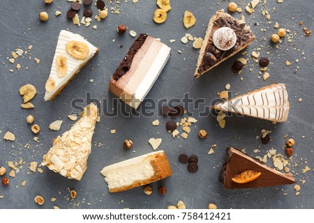 Assortment of pieces of cake on messy table, copy space. Several slices of delicious desserts, restaurant menu concept, top view Royalty-Free Stock Photo #758412421