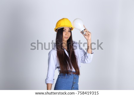 Beautiful Asian Architect Engineer woman in yellow hard hat, blue shirt jean skirt, Idea Light Bulb, studio lighting gray background copy space, concept woman can do