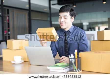 Asian Businessman holding box while working at office. People working concept.