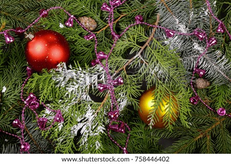 Christmas background, decor, attributes, on a wooden background. Set of fresh fir branches and ornaments of red and gold balls. Cones and bells.
