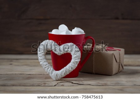 Marshmallow in a red cup, gift box and heart.