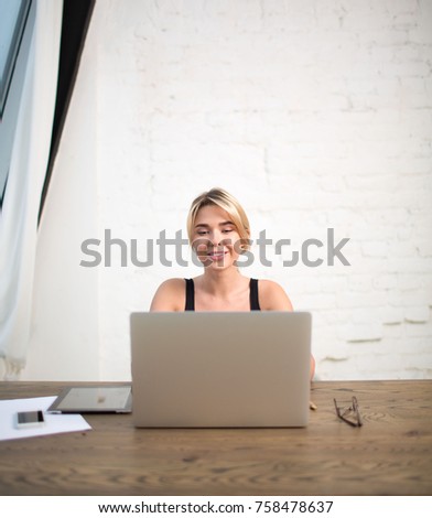 Smiling woman successful business planning expert working on laptop computer, sitting in office company. Cheerful female manager searching financial information in internet via portable net-book.