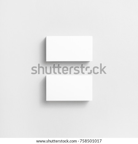 Photo of blank business cards with soft shadows on paper background. For design presentations and portfolios. Top view.