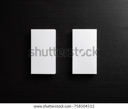 Photo of blank business cards on black wood background. Template for ID. Mock up for branding identity. Top view.