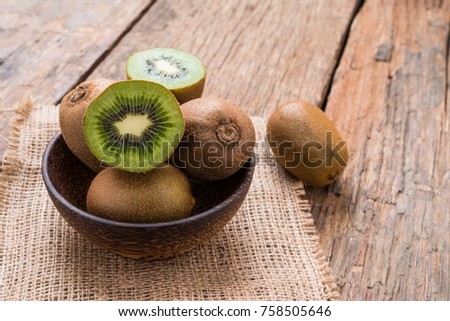 Kiwi fruit in a bowl on wooden background.  With copy space
