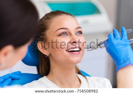 Tooth extraction beautiful girl in dentistry. Royalty-Free Stock Photo #758508982