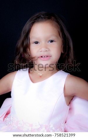Young girl poses for a picture. Isolated on black background